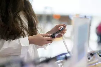 a woman in the electronics store choosing the new smartphone