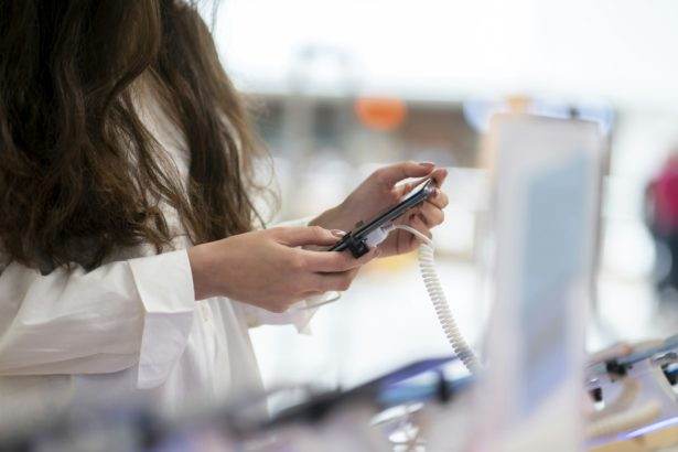 a woman in the electronics store choosing the new smartphone