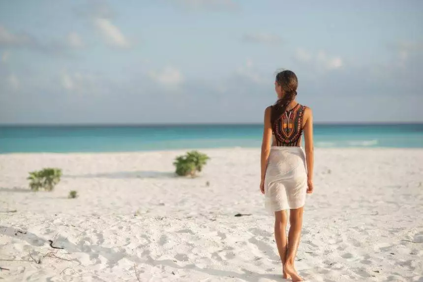 Brunette girl on a luxury vacation on the beach in the Maldives