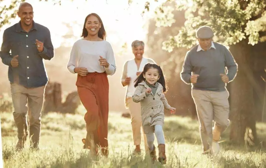 Family, running and parents or grandparents with girl child in park for freedom, adventure or playi