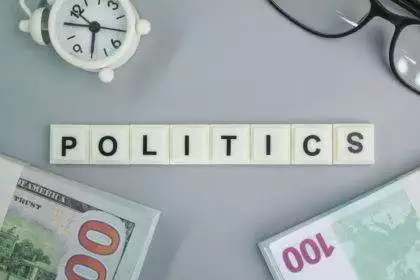 paper money, glasses, bell clock with political words